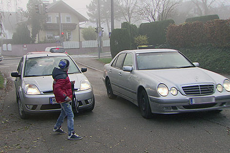 Kind mit Autos auf der Straße