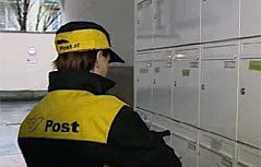 Briefträgerin bei Postkästen