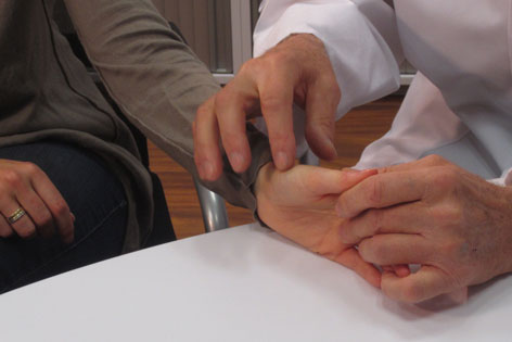 Arzt befühlt das Fingergelenk eines Patienten