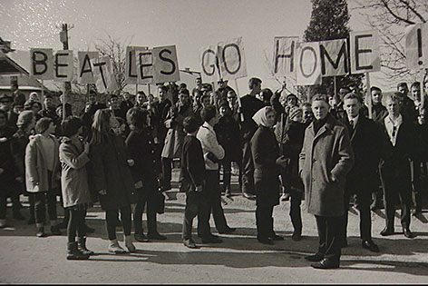 Fotografie Menschenmenge mit Schild auf dem steht "Beatles go Home"