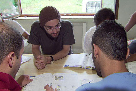 Freiwillige Flüchtlingshelfer beim Unterrichten