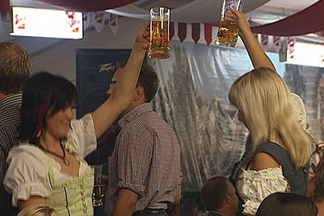 Junge Frauen mit Bierkrügen in Dirndl im Bierzelt