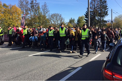 Flüchtlinge marschieren in Polizeibegleitung Richtung Freilassing