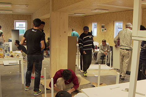 Flüchtlinge beim Zusammenbauen von Möbeln im Holz-Flüchtlingsquartier in Seekirchen