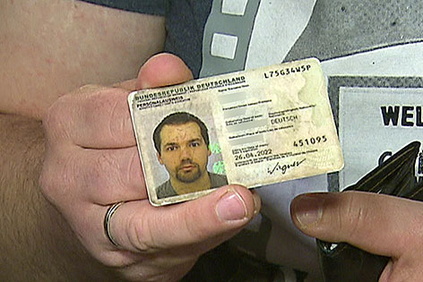 Mann hält deutschen Personalausweis in der Hand
