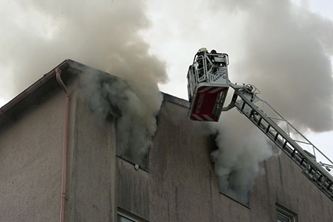 Feuerwehrleute bei Löscharbeiten bei Wohnhaus in Salzburg Liefering