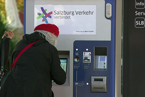 Alte Frau vor einem Ticketautomaten des Salzburger Verkehrsverbundes