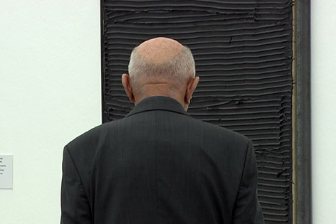 Mann steht vor Bild von Jakob Gasteiger im Museum
