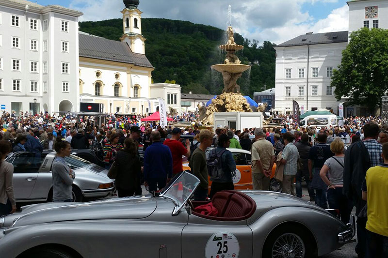 Besucher und Oldtimer bei Autoparade auf dem Residenzplatz in der Salzburger Altstadt