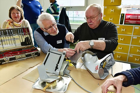 Freiwillige beim Repair Cafe reparieren Schneidemaschine