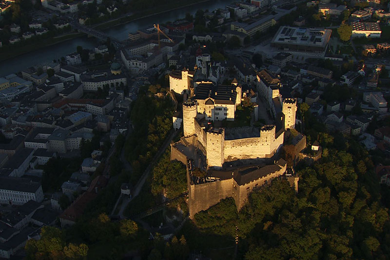 Festung Hohensalzburg und die Salzburger Altstadt im Abendlicht aus der Luft gesehen