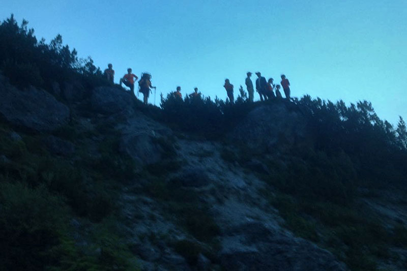 Bergretter über steilem Abhang in der Abenddämmerung