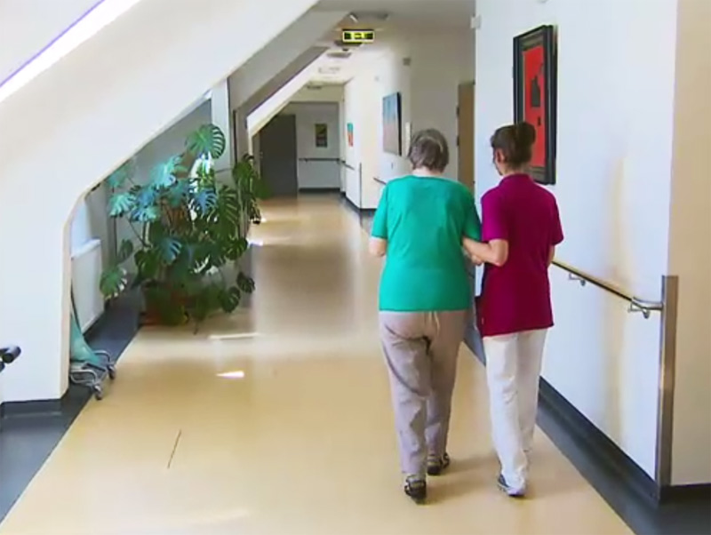 Pflegerin mit Frau in Seniorenheim