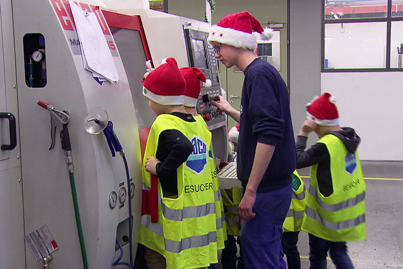 Kinder mit Weihnachtsmützen in Werkstatt des Beschlägeherstellers MACO in der Stadt Salzburg