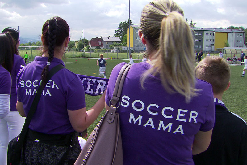 Mütter von Nachwuchsfußballern mit Leibchen mit dem Aufdruck "Soccer Mama"