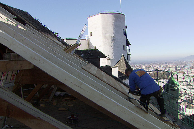 Zimmerer arbeiten an Dachstuhl auf der Salzburger Festung